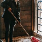 Person cleaning out a cow shed